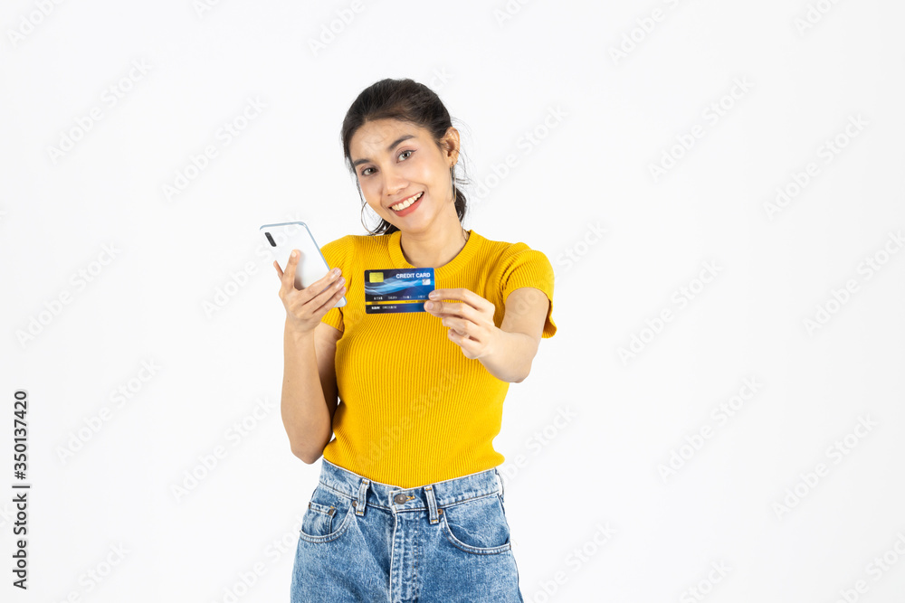 Attractive young Asian woman holding mobile smart phone and credit card on white isolated background. Shopping online concept. Attractive young Asian woman holding mobile smart phone and credit card on white isolated background. Shopping online concept.