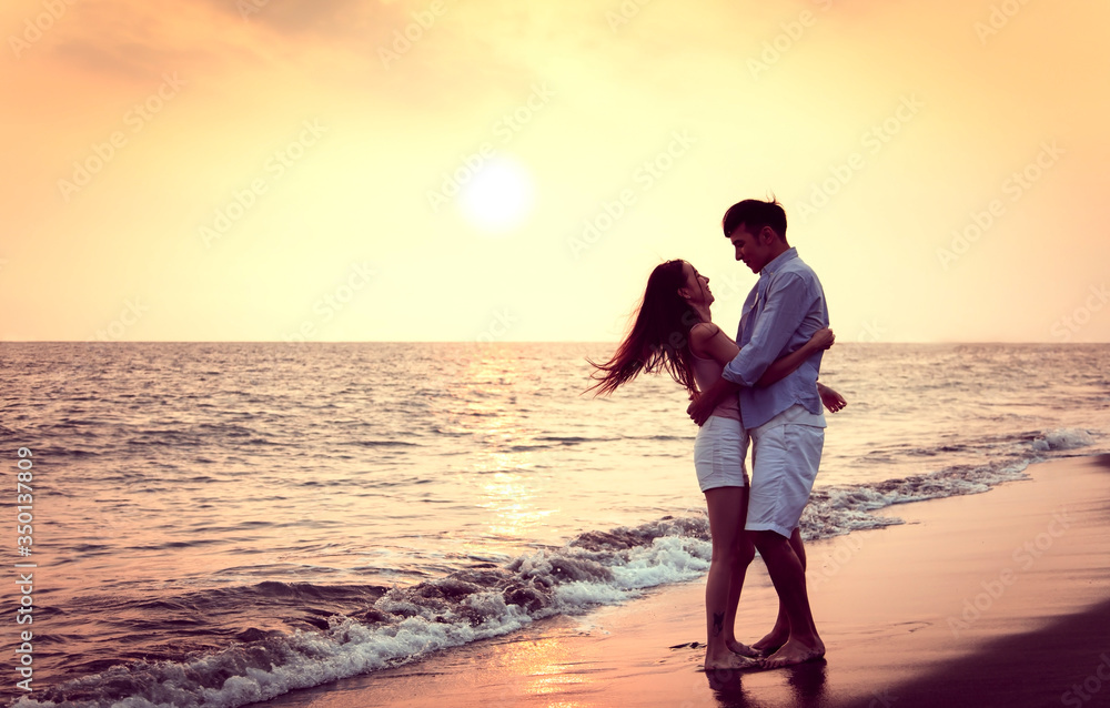 Romantic young Couple hug on the beach at sunset
