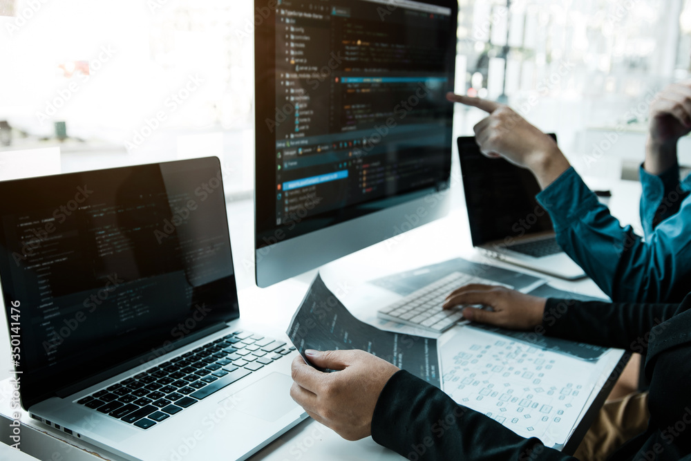 Two asian team working development of programming and encryption technology website design programmers on desk in office. Two asian team working development of programming and encryption technology website design programmers on desk in office.