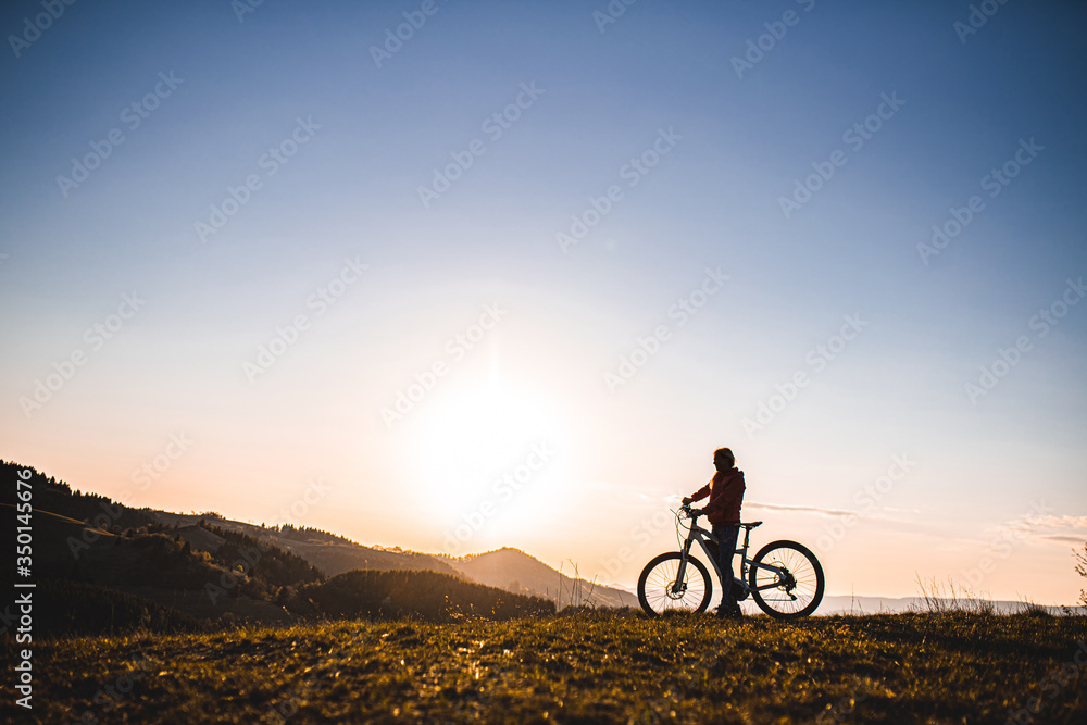 Active senior woman with e-bike outdoors in nature at dusk. Copy space. Active senior woman with e-bike outdoors in nature at dusk. Copy space.