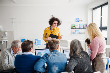 Group of senior people attending computer and technology education class.