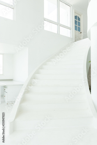 front view of white indoor cement stone staircase without railing in minimal building