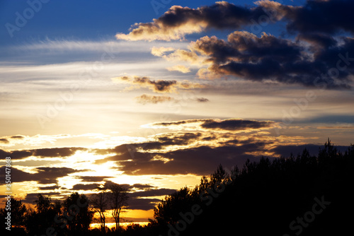 This is a sunset with clouds and woods.  © MaHubert