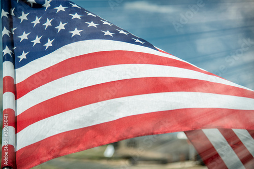Waving american flag against a blue sky