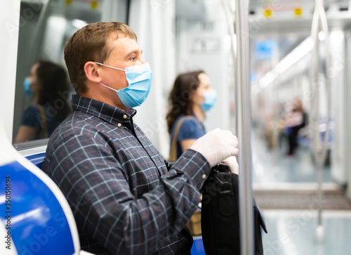 Man in medical mask riding in subway car
