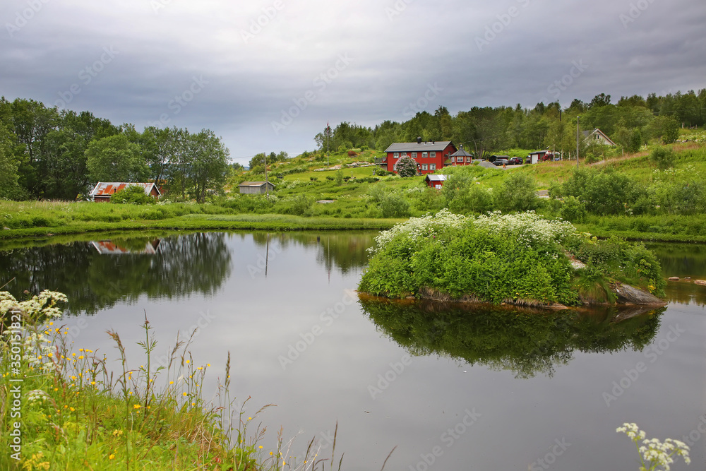 Beautiful landscape along with waters edge, with a village & church & mountains in the background, Saltstraumen, Municipality of Bodo, Nordland county, Norway. Beautiful landscape along with waters edge, with a village & church & mountains in the background, Saltstraumen, Municipality of Bodo, Nordland county, Norway.