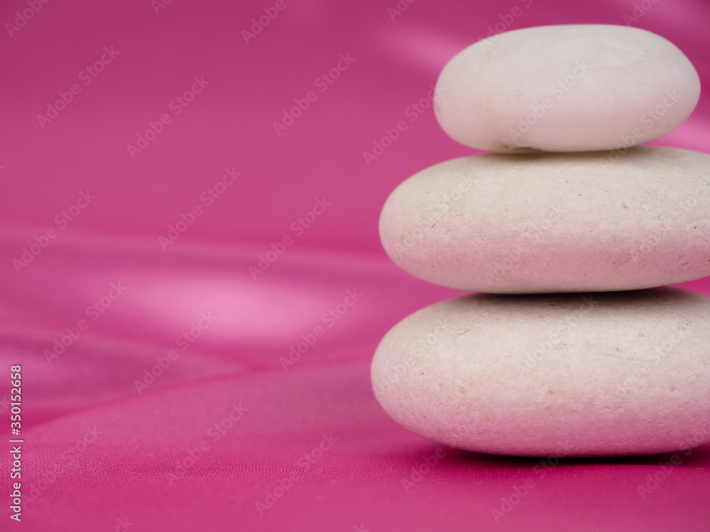 Zen stones on a pink background, Studio shot of rocks balancing on one another Zen stones on a pink background, Studio shot of rocks balancing on one another