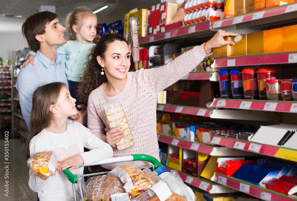 parents with two kids choosing biscuits in store
