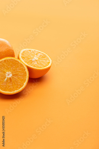 ripe delicious cut and whole oranges on colorful background