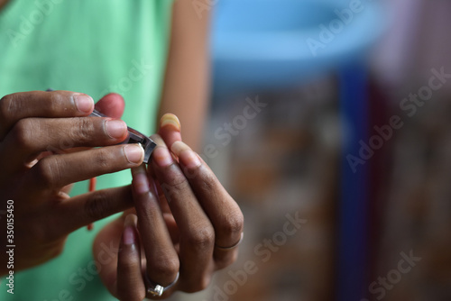 after corona virus lockdwon every parlour and saloon has been closed so Indian girl clean and cut our nails at home, with shallow depth of field, Lock down India