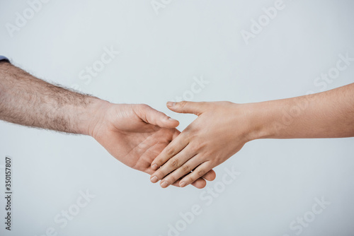 Cropped view of man and woman handshaking isolated on grey