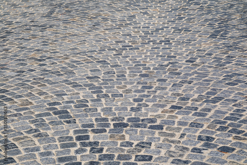 Brick stone street pavement close up background. Empty dark stone pavement on old town ancient street, abstract cobblestone paved road pattern Brick stone street pavement close up background. Empty dark stone pavement on old town ancient street, abstract cobblestone paved road pattern