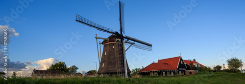 Panoramic view on countryside with old buildings and windmill in the netherlands
