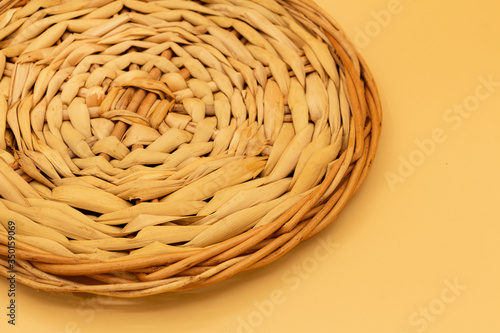 Part of a round stand created by intertwining vines on a light background.