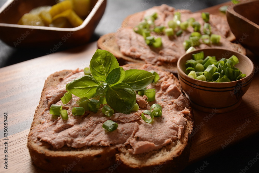 Chicken or goose liver pate sandwiches on a wooden board Chicken or goose liver pate sandwiches on a wooden board