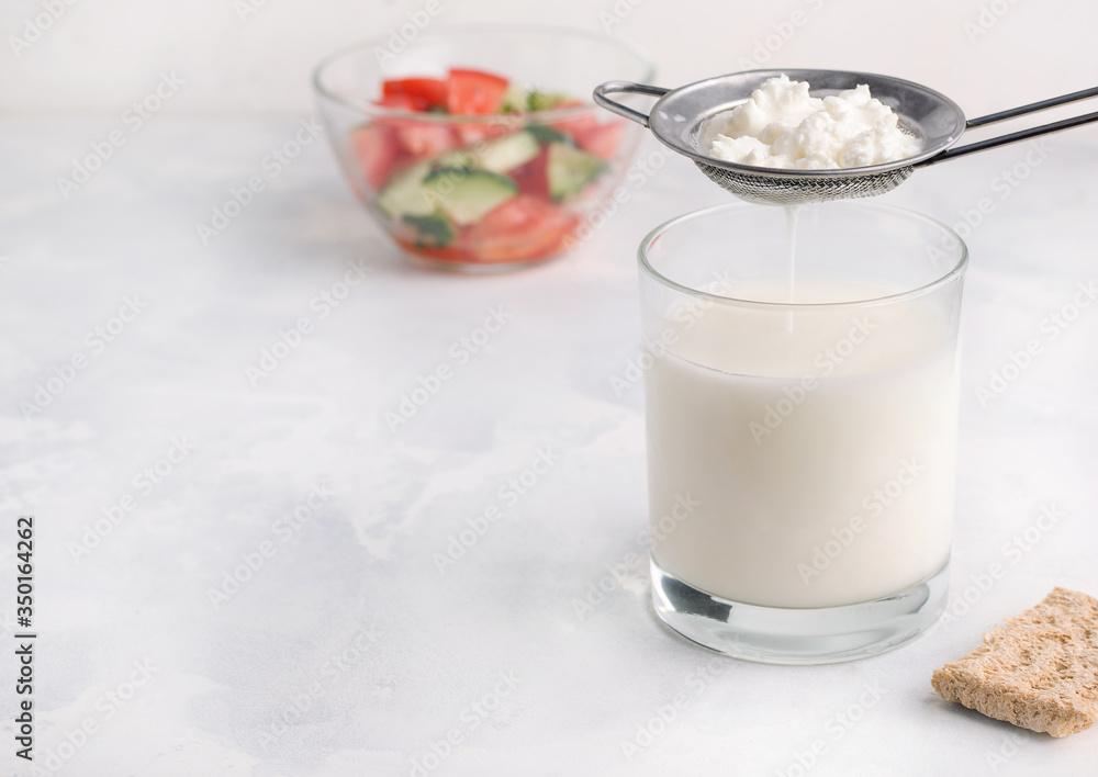 Fermented milk product drink kefir in a glass on a white background. Healthy breakfast concept Fermented milk product drink kefir in a glass on a white background. Healthy breakfast concept