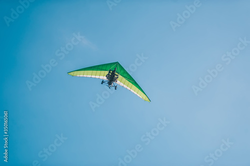 The motorized hang glider in the clear blue sky