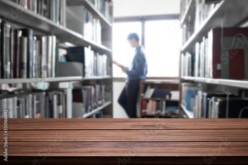 Empty wooden desk space platform with library background for product display montage. Education concept. © qOppi