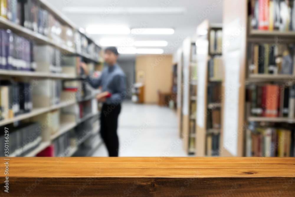 Empty wooden desk space platform with library background for product display montage. Education concept.