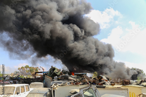 Big column of smoke coming from a burning cars