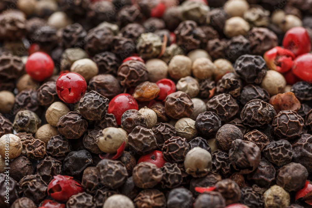 Close up of Mixted multi coloured peppercorns. white, black and green peppercorns macro background.Mixed peppercorns red black and white in bowl - Close-up. Close up of Mixted multi coloured peppercorns. white, black and green peppercorns macro background.Mixed peppercorns red black and white in bowl - Close-up.