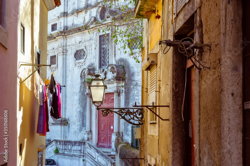 Street lamp and laundry in a picturesque narrow street of Alfama in the old town of Lisbon, Portugal © Delphotostock