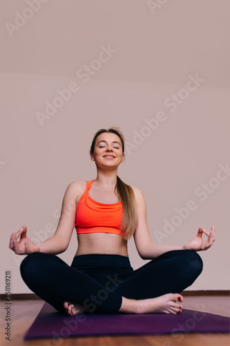Fototapeta Naklejka Na Ścianę i Meble -  Young attractive woman does yoga exercise in living room. Breath