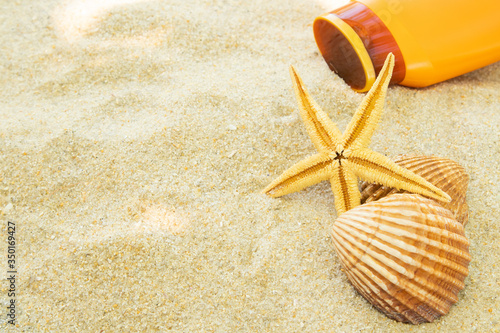 beach sand with seashells and sun cream