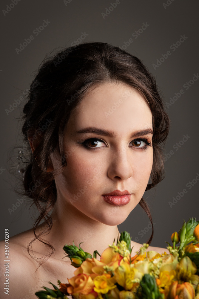 Fototapeta premium Bride in white dress with bouquet in photostudio