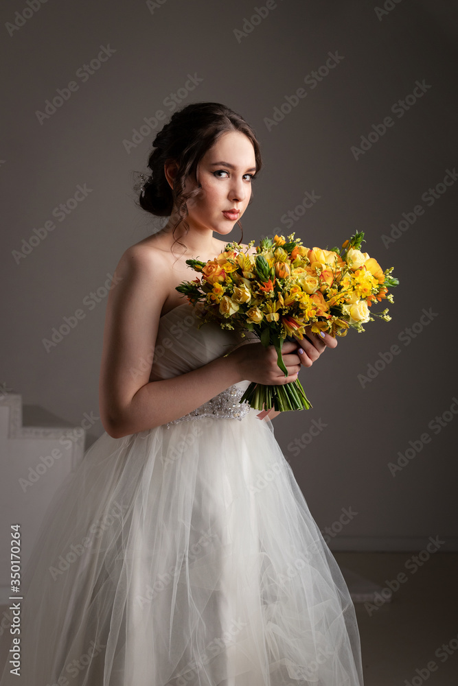 Bride in white dress with bouquet in photostudio Bride in white dress with bouquet in photostudio