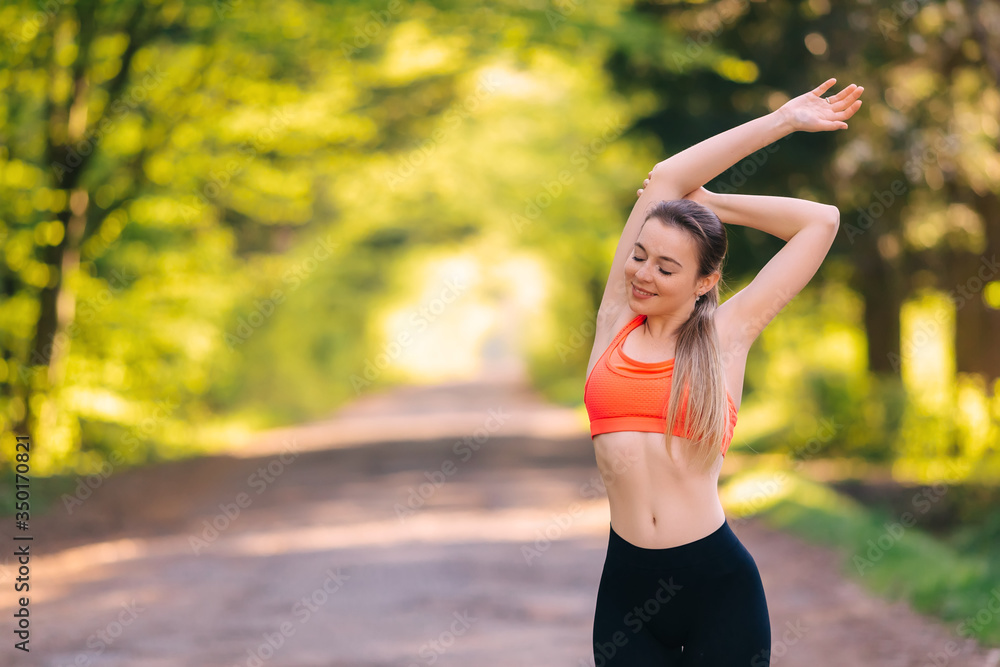 Attractive girl dressed in a sports pink top and leggins doing s Attractive girl dressed in a sports pink top and leggins doing s