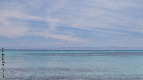 Sea and sky with wispy clouds. Soft pastel colors. Calm and tranquility.