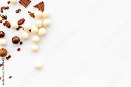 Candy background with chocolate on white table top view frame. Sweets desserts concept. Space for text