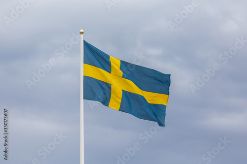 Swedish flag as proudly fluttering in the wind against a blue sky