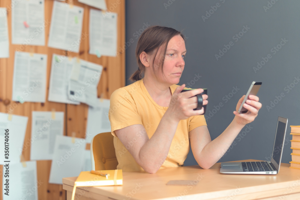 Female freelancer working on smartphone and drinking coffee Female freelancer working on smartphone and drinking coffee