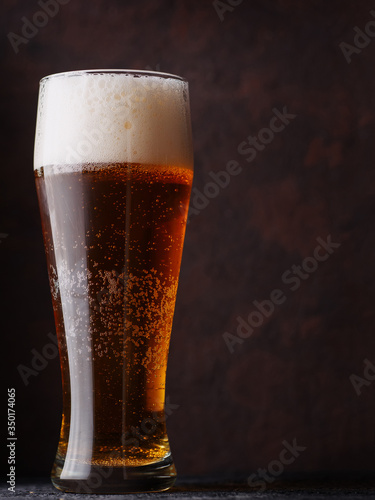 Wallpaper Mural A tall glass of beer on a brown background Torontodigital.ca