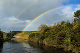 A double rainbow above a rural river