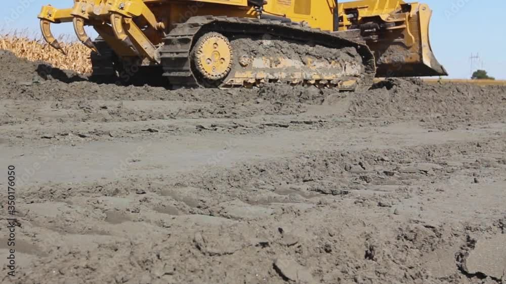 Close up view on bulldozer's undercarriage during pushing sand at construction site. Close up view on bulldozer's undercarriage during pushing sand at construction site.