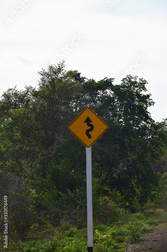 Traffic sign twisty road on a yellow iron sheet Located along the road