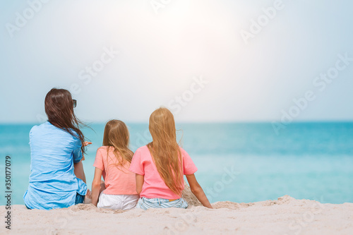 Mother and little daughters at tropical beach