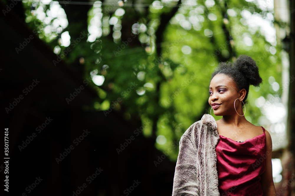 Portrait of a beautiful natural young African woman with afro hair. Black model in red silk dress. Portrait of a beautiful natural young African woman with afro hair. Black model in red silk dress.