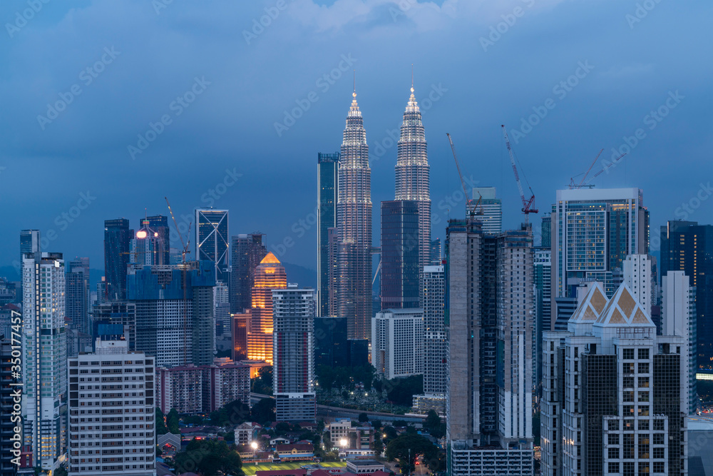 Fototapeta premium Panoramic view of Kuala Lumpur skyline at night time. City center of capital of Malaysia. Illumination lights contemporary buildings exterior with glass.