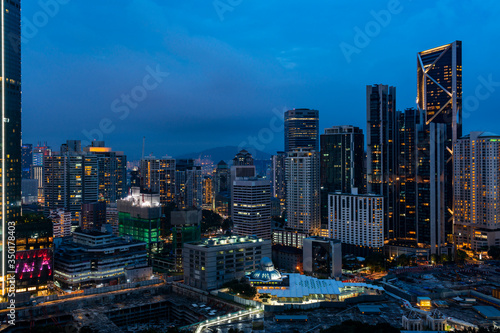 Panoramic view of Kuala Lumpur skyline at night time. City center of capital of Malaysia. Illumination lights contemporary buildings exterior with glass.