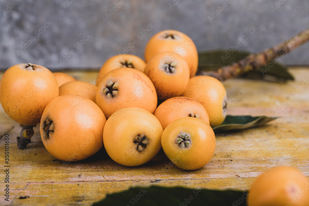 Fresh loquats, recently recolted from a trea lay on a wooden textured table. Beautiful rustic image Fresh loquats, recently recolted from a trea lay on a wooden textured table. Beautiful rustic image