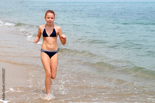  girl in a swimsuit runs along the sea  © Anna
