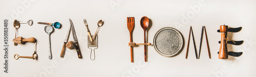 Stay at home lettering made from kitchen utensils, top view. Flat lay of stay at home words for quarantine isolation during coronavirus pandemic. Banner for website for food shop photo