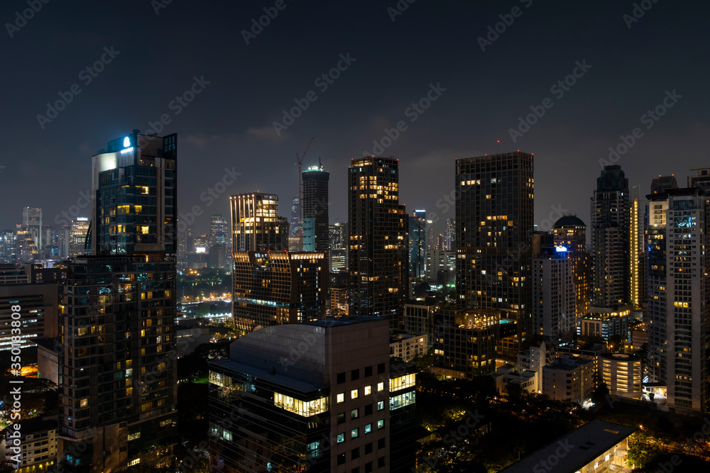 Panoramic view of Bangkok skyline at night time. Illuminated city center of capital of Thailand. Contemporary buildings exterior with glass.