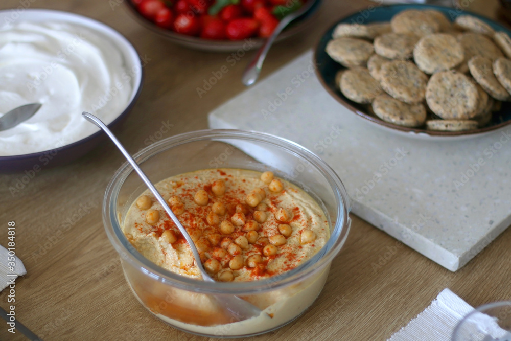 Bowl of homemade hummus served on a table. Selective focus. Bowl of homemade hummus served on a table. Selective focus.