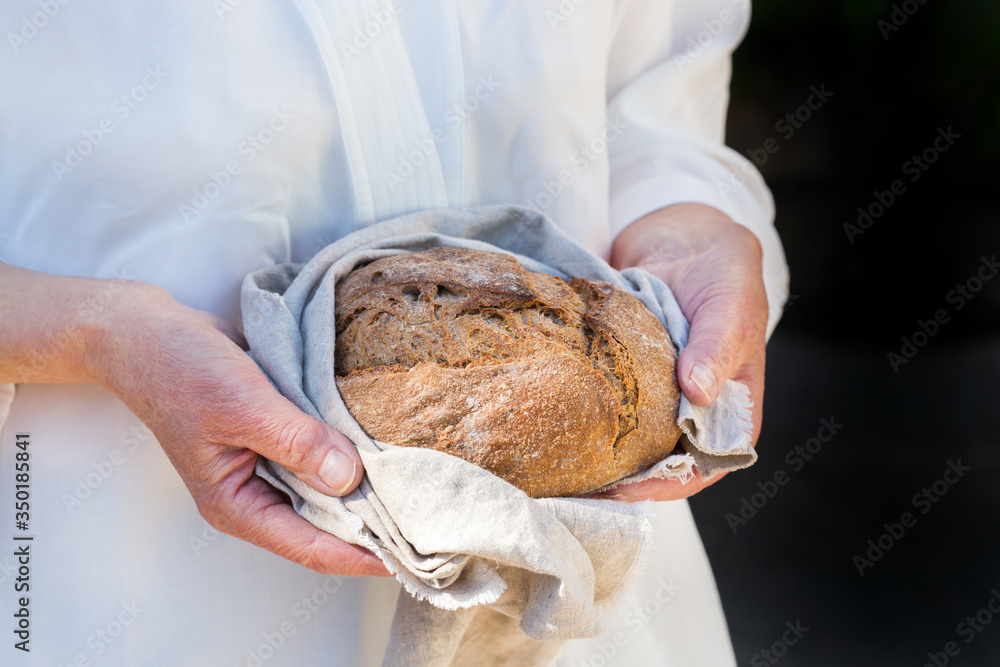 Fresh loaf of homemade rye bread in woman hands Fresh loaf of homemade rye bread in woman hands