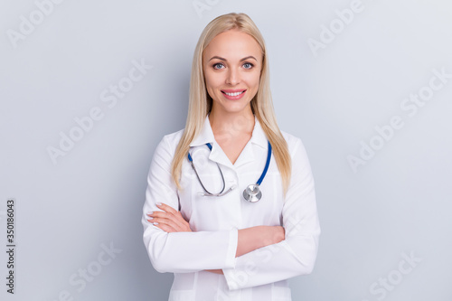 Close-up portrait of her she nice attractive content lovely charming pretty cheerful blonde girl skilled medic expert specialist therapy treatment folded arms isolated on grey pastel color background